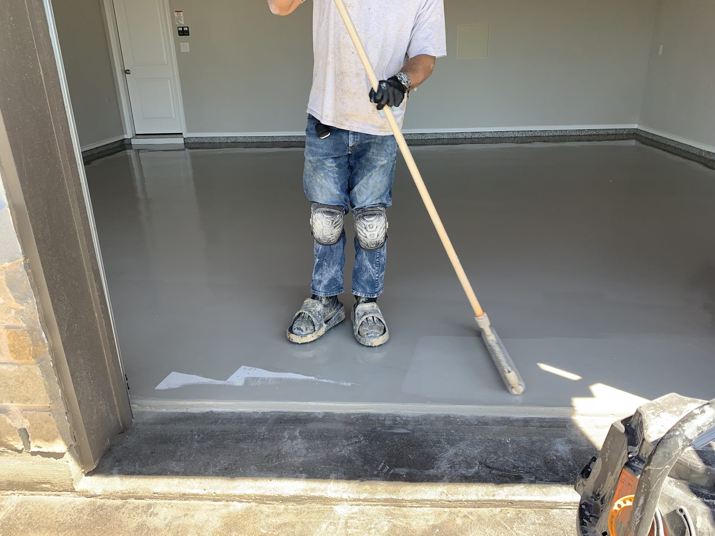 Classic installer rolling the base coat onto a garage floor